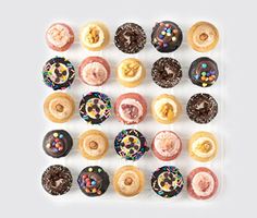 an assortment of doughnuts arranged on a white surface