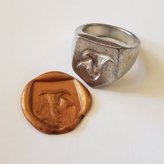 a wax seal and a ring on a white surface with a small metal object in the middle