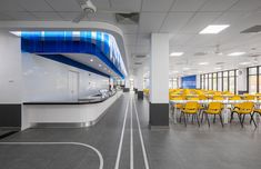 an empty room with yellow chairs and tables