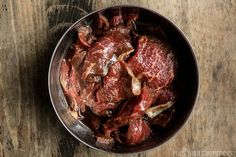 raw meat in a metal bowl on a wooden table