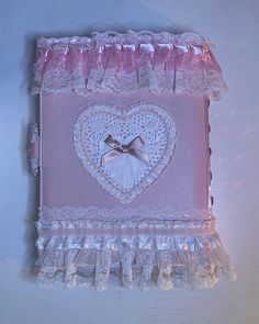 a pink and white heart shaped box with lace trim