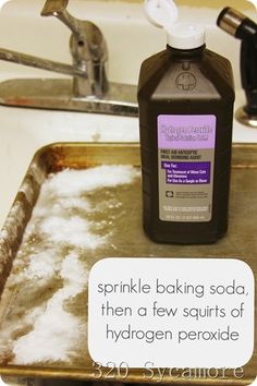 a bottle of baking soda sitting on top of a metal tray next to a sink