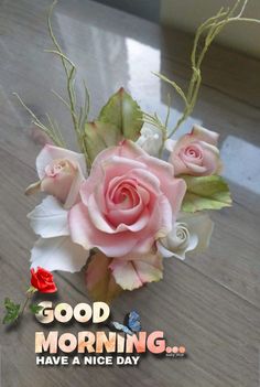 a bouquet of pink roses sitting on top of a wooden table with the words good morning have a nice day