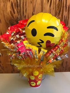 a yellow balloon in a vase filled with candy