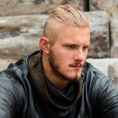 a close up of a person wearing a leather jacket and looking off to the side