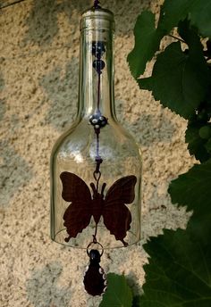 a glass bottle with a butterfly hanging from it