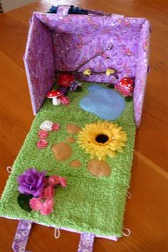 a purple and green doll house with flowers on the floor