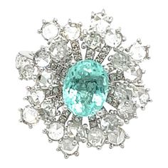 18K White Gold Paraiba Tourmaline Ring with Diamonds 1 Paraiba - 11.670CT 24 Diamonds - 1.450CT 130 Diamonds - 0.720CT 18K White Gold - 6.580GM Exquisitely crafted in gleaming 18K white gold, this breathtaking ring showcases a stunning Paraiba tourmaline as the centerpiece. The vibrant, 11.67 carat Paraiba tourmaline, known for its mesmerizing blue-green hues, takes center stage, surrounded by a sparkling halo of brilliant-cut diamonds. The gems are expertly set, creating a captivating floral de Luxury Cluster Diamond Ring With Gemstone, Fine Jewelry Platinum Cluster Ring With 17 Jewels, Fine Jewelry Platinum Cluster Ring, Luxury Multi-stone Cluster Diamond Ring, Luxury Multi-stone Diamond Cluster Ring, Platinum Multi-stone Gemstones In Fine Jewelry Style, Fine Jewelry Platinum Multi-stone Gemstones, Luxury Multi-stone Emerald Ring With Diamonds, Multi-stone Cluster Platinum Jewelry