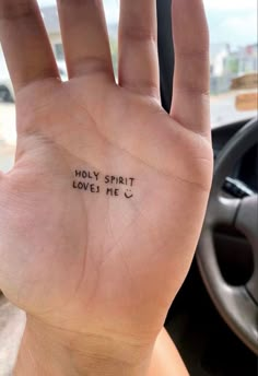 a person's hand with the words holly spirit loves me written on it in black ink