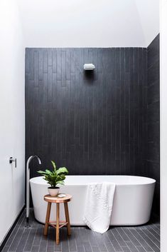 a white bath tub sitting next to a wooden stool