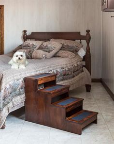 a small white dog sitting on top of a bed next to some steps in front of it