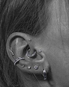 a close up of a person with ear piercings on their ears and behind the ear