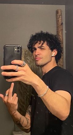 a man taking a selfie in front of a mirror with his hand on the phone