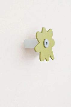 a yellow flower with an eye on it is attached to a white doorknob