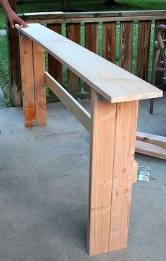 a wooden bench sitting on top of a cement ground