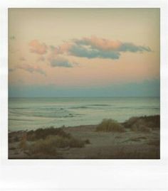 an ocean view with clouds in the sky