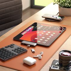 an ipad, keyboard and other electronics are sitting on a table next to a camera