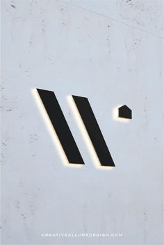 an illuminated sign on the side of a building with two arrows pointing in opposite directions