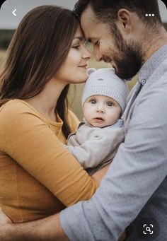 a man and woman holding a baby in their arms