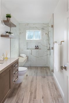 a bathroom with wood flooring and white walls, along with a walk in shower