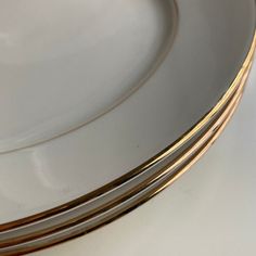 three plates stacked on top of each other with gold trimming around the rims