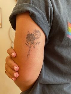 a woman's arm with a flower tattoo on the left side of her arm