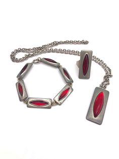 "This striking 1960s Jorgen Jensen Denmark Modernist pewter necklace, bracelet and ring,  feature rich red cabochon (glass) centers. The Pendant measures 1-5/8\" long x 5/8\" wide and has a 28\" long chain.  The ring measures 1 3/8\" long and 9/16\" wide and is adjustable.  The bracelet measures 8\" long and the links measure 1\" x 7/16\" wide. All pieces are stamped \"PEWTER / Jorgen Jensen / DENMARK \", and are in very good vintage condition." Bracelet And Ring, Bracelet Ring, Long Chain, Necklace Bracelet, Ring Bracelet, Denmark, Jewelry Sets, 1960s, Stamp