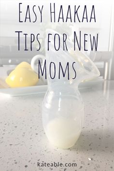 a glass pitcher filled with milk sitting on top of a counter next to lemons