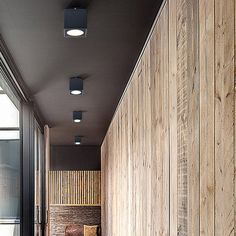 the hallway is lined with wood planks and has two lamps