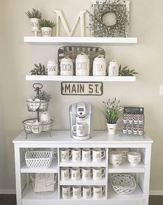 a white shelf with coffee cups and mugs on it in front of a sign that says main st