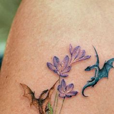 a tattoo with flowers and a dragon on it