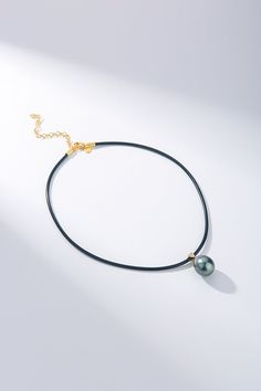 Embrace a blend of modern style and natural elegance with our Large Tahitian Pearl Pendant Leather Cord Necklace. This chic piece features a 13-14mm water-drop shaped Tahitian pearl, renowned for its smooth surface and striking black color enhanced by exceptional luster. Set in an 18K gold pendant fitting and paired with a leather cord, this necklace measures 45.5cm with a 7cm extension for adjustable comfort. Perfect for those who favor a contemporary and youthful approach to classic pearl jewelry. Product Details: Pearl Type: Tahitian Pearl Pearl Size: 13-14mm Pearl Shape: Water-drop Pearl Color: Black Pearl Luster: High Cord Material: Leather Cord Length: 45.5cm with 7cm Extension Metal: 18K Gold Pendant Fitting Style: Modern, Fashion-Forward Occasion: Ideal for adding a sophisticated y Luxury Black Necklace With Pearl Pendant, Luxury Black Tahitian Pearl Necklaces, Elegant Black Pendant Pearl Necklace, Black Tahitian Pearl Pendant Necklaces, Black Tahitian Pearl Pendant Necklace, Pearl Drop Earrings Wedding, Classic Pearl Jewelry, Floating Pearl Necklace, Tahitian Pearl Pendant