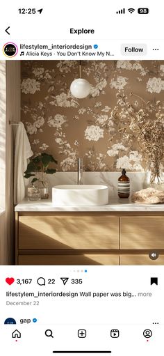 the bathroom is decorated with floral wallpaper and white sink faucets in front of a mirror