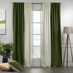 a living room with green and white drapes on the windowsill, potted plant in front of it