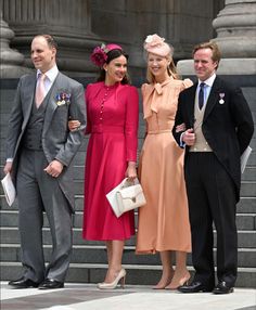 three men and two women in formal wear standing on steps with one woman holding a purse