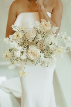 a woman in a white dress holding a bouquet of flowers