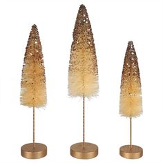 three decorative trees with gold colored feathers on each one and two smaller ones in the middle