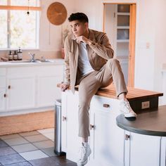 a man sitting on top of a kitchen counter