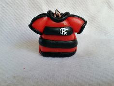 an ornament shaped like a red shirt with black and white stripes on it