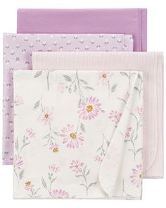 three napkins with pink and purple flowers on the front, one is folded in half