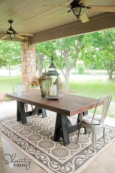 an outdoor dining area with a table, chairs and ceiling fan on the patio outside