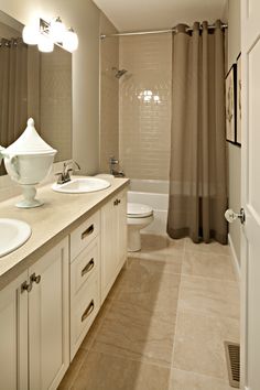 a bathroom with two sinks, a toilet and a bathtub next to a shower