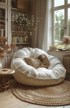 a white bean bag chair sitting on top of a rug in front of a window