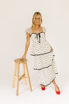 the retro-inspired dress of our dreams. it features sheer short sleeves, a ribbon tie bodice, + dainty ruffle details. both sweet + sophisticated, this off-white + black polka dot midi dress is perfect for fancy dinner dates, holiday parties, + anytime you’re feelin’ frilly. off white + black polka dots // midi length, sweetheart neckline, sheer polka dot sleeves, back zipper closure, tiered skirt, lined model is 5'8" + wearing a small measurements are approximate + taken while laying flat xsmal Retro Inspired Dress, Polka Dot Midi Dress, Dinner Dates, Sheer Shorts, Fancy Dinner, Date Dinner, Tier Skirt, Ribbon Tie, Inspired Dress