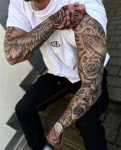 a man with tattoos on his arm sitting down