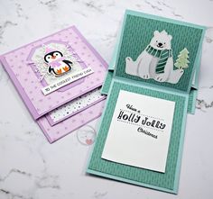 three cards with penguin, polar bear and snowman on them sitting on a table