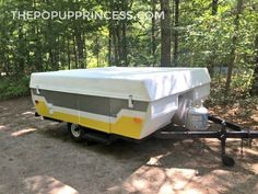 a trailer with a cover on it parked in the woods