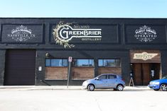 two cars parked in front of a building with greenbrier brewery on it's side