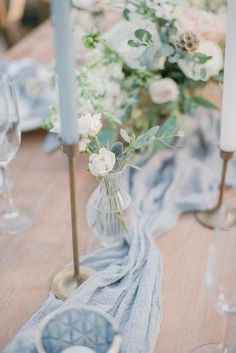 the table is set with flowers and candles