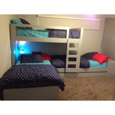 two bunk beds with blue and red pillows on them in a room that has carpeted flooring